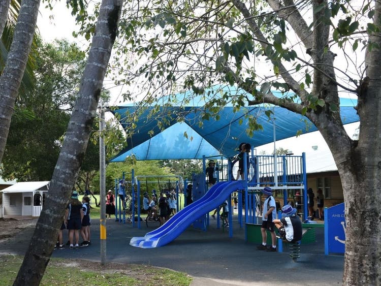 playground enquipment and slide surrounded by small trees